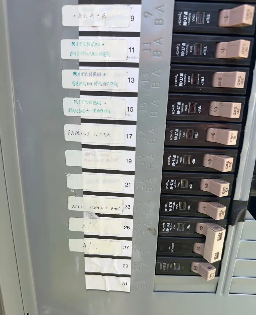 A handwritten circuit directory label inside an electrical panel listing garage, kitchen, dishwasher, refrigerator and other circuits