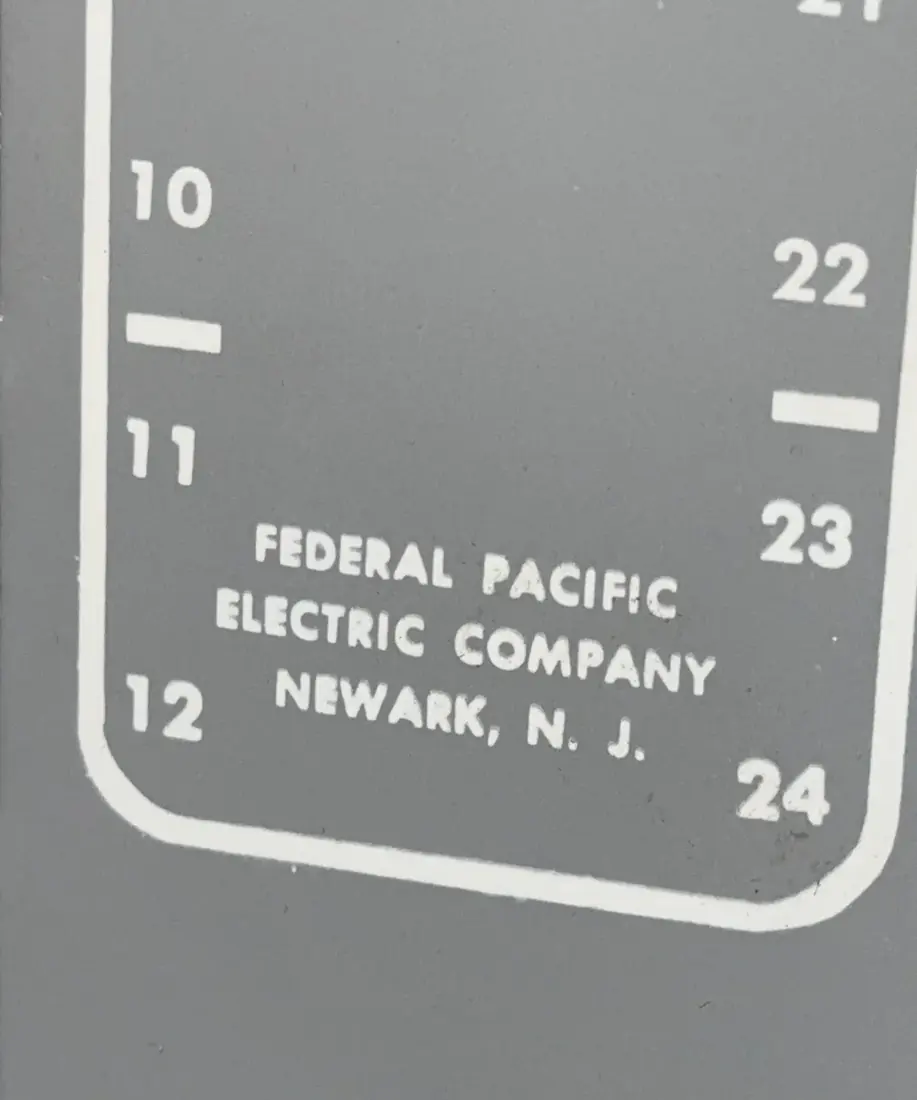 Close view of embossed lettering reading Federal Pacific Electric Company, Newark, N. J. on an electrical panel deadfront
