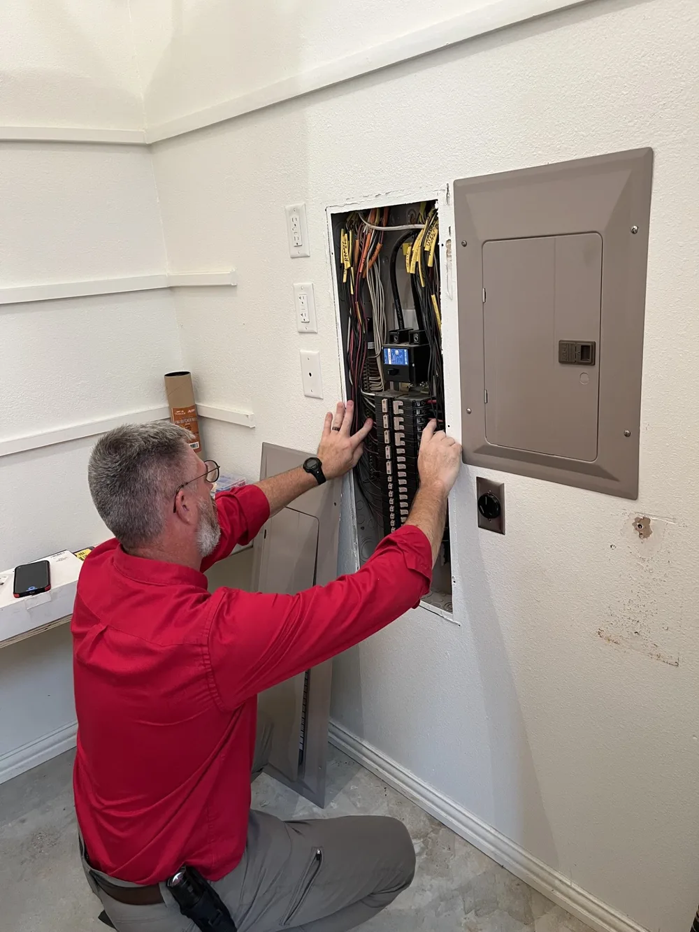 Jeff Stalnaker removing the deadfront cover from an electrical panel during an inspection